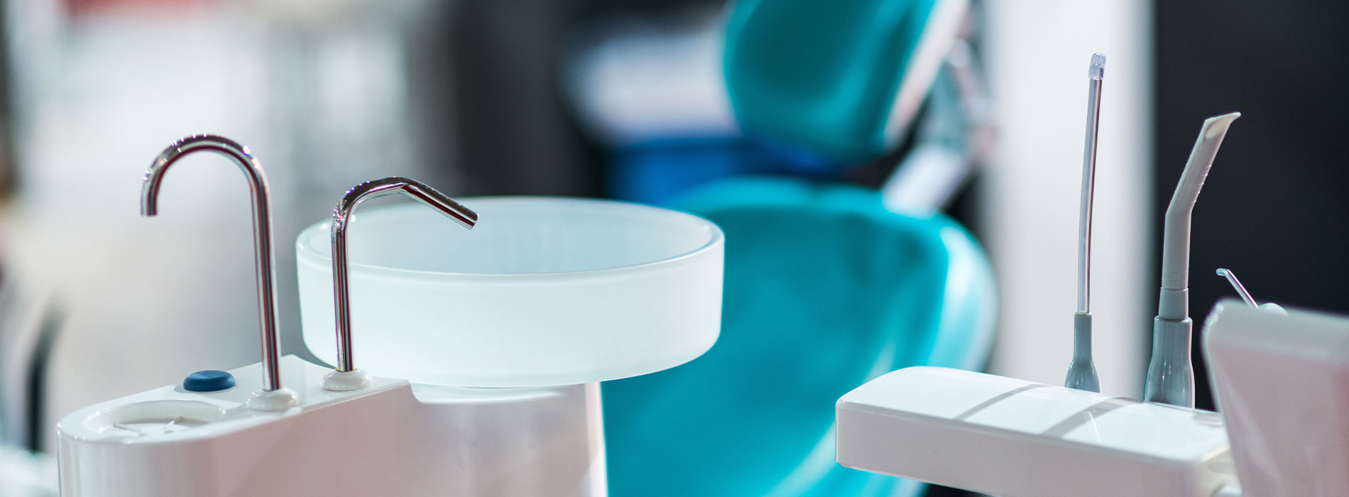 The image shows a modern dental clinic interior with various pieces of equipment, including a dental chair and an X-ray machine.