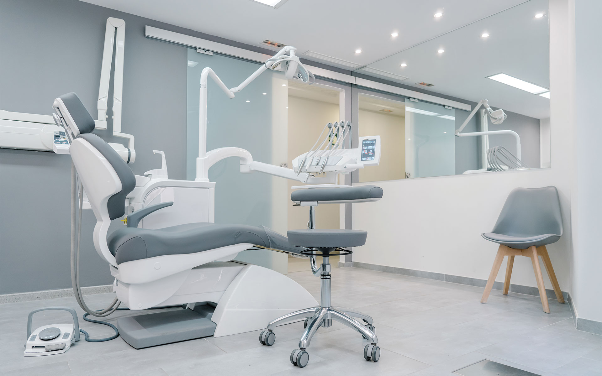 The image shows a dental office interior with a dental chair, a dental light, and various dental equipment.
